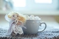 Angel in white lace dress with hands folded in prayer. homemade sock toy with fluffy red hair in background of window. cup of Royalty Free Stock Photo