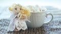 Angel in white lace dress with hands folded in prayer. homemade sock toy with fluffy red hair in background of window. cup of Royalty Free Stock Photo