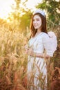 Angel woman in a grass field with sunlight Royalty Free Stock Photo