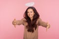 Angelic kindness and generosity. Portrait of beautiful young woman with halo above head holding outstretched hands