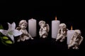 Angels with candles and white lily flower on a black background Royalty Free Stock Photo