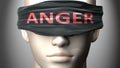 Anger can make things harder to see or makes us blind to the reality - pictured as word Anger on a blindfold to symbolize denial