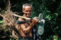 elderly senior khmer man walking home from his farm with some roots and his tool in his hand