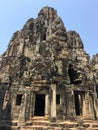 Angkor Wat in Siem Reap, Cambodia. Stone faces carved in the ancient ruins of Bayon Khmer Temple Royalty Free Stock Photo