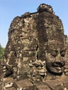 Angkor Wat in Siem Reap, Cambodia. Stone faces carved in the ancient ruins of Bayon Khmer Temple Royalty Free Stock Photo