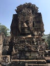Angkor Wat in Siem Reap, Cambodia. Stone faces carved in the ancient ruins of Bayon Khmer Temple Royalty Free Stock Photo
