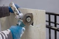 Angle grinder with an cutting ceramic tiles a square hole in the tile Royalty Free Stock Photo