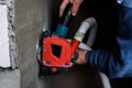Angle grinder with protective exhaust casing and two diamond discs for cutting grooves in wall.