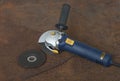 Angle grinder with thinner cut-off disc and  grinding disc on  old rusty metal sheet Royalty Free Stock Photo