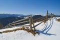 Landscape with old wooden fence at snowy hill