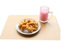 Angle view of deep-fried dough stick with pink cold drink on woo