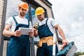 Angle view of handsome repairmen looking at digital tablet