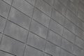 Angle view of modern just placed gray ceramic tiles with dark joint. Backdrop, texture or pattern for design.