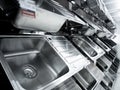 Angle view of rows metal kitchen sink at the showroom of a large store.