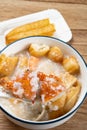 spoon taking out crab from seafood porridge with deep-fried dough sticks