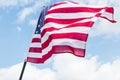 Angle view of usa flag with stars and stripes against blue sky with clouds Royalty Free Stock Photo