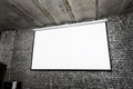 Angle view of white projector screen on gray brick wall Royalty Free Stock Photo