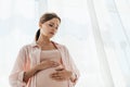 Angle view of worried pregnant woman touching belly and looking down Royalty Free Stock Photo