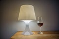 Angled bedside lamp with a glass of whiskey next to it