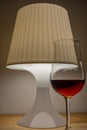 Angled bedside lamp with a glass of whiskey next to it