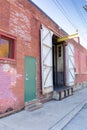Angled side of a commercial industrial building, red brick and old wood loading dock doors, weathered architectural details Royalty Free Stock Photo