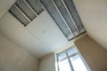 Angled view of light empty room under construction. Suspended ceiling and walls from drywall fixed to metal frame with screws. Ren Royalty Free Stock Photo