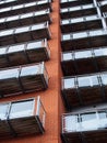 Angled view of modern apartment building with windows in brick walls and glass balconies Royalty Free Stock Photo