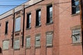 Angled view of an old red brick commercial industrial warehouse, lower window spaces filled with glass block Royalty Free Stock Photo