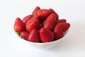 Angled view of organic and fresh red strawberries in white bowl. Royalty Free Stock Photo