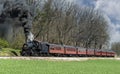 Angled View of a Restored Steam Passenger Train Moving Slowly Blowing Lots of Black Smoke