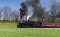 Angled View of a Restored Steam Passenger Train Moving Slowly Blowing Lots of Black Smoke