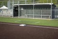 Angled view of a white base on a baseball field, with the view of a dugout in the background Royalty Free Stock Photo