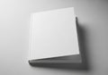 An angled view of a white, hardbound book on a light gray surface. Royalty Free Stock Photo
