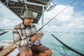 angler checking the reel before fishing with a fishing rod Royalty Free Stock Photo