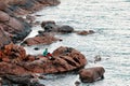 Angler fisherman sitting on the rocks and fishing with rods near the seaside