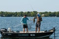 Pair of Anglers Fishermen in Boat Landing and Netting a Smallmouth Bass Royalty Free Stock Photo