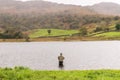Angler in waders waiting for a catch at Watendlath