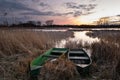 Anglers boats in reeds on the lake shore and the evening sky after sunset Royalty Free Stock Photo