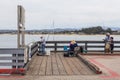 Anglers fishing on a wooden pier, Monterey, USA