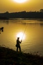 Anglers in romantic mood on the banks of a river at sunset Royalty Free Stock Photo