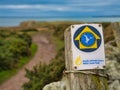 Anglesey, UK - Jan 11 2024: A weathered, wooden sign pointing the way for walkers on the Wales Coast Path on the island Anglesey Royalty Free Stock Photo