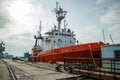 Orange fishing vessel docked at port. Angling boat ready for maritime journey. Industrial trawler for commercial fishery