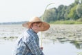 Angling teenage boy with handmade green twig fishing rod is looking back Royalty Free Stock Photo