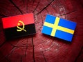 Angolan flag with Swedish flag on a tree stump Royalty Free Stock Photo