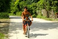 Young Filipino children play and ride a bicycle along a street