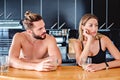 Angru couple sitting at the kitchen pult and holding coffee