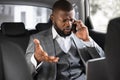 Angry african american businessman talking on phone in car Royalty Free Stock Photo
