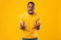 Angry African American Man Shouting Expressing Anger Over Yellow Background