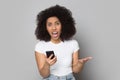 Angry african american woman irritated by broken device, low battery. Royalty Free Stock Photo