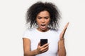 Angry African American woman looking at phone, annoyed by spam Royalty Free Stock Photo